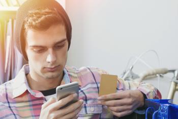 Student mit Kreditkarte in der Hand